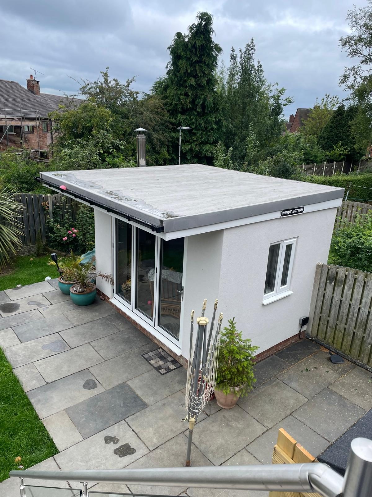 Flat-roof garden building with glazed doors and a paved terrace