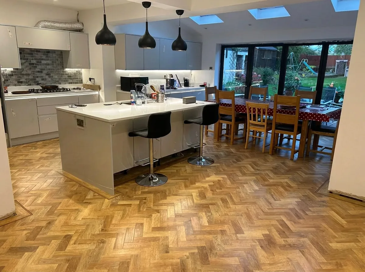 Fitted kitchen with island, pendant lights, parquet flooring and rooflights