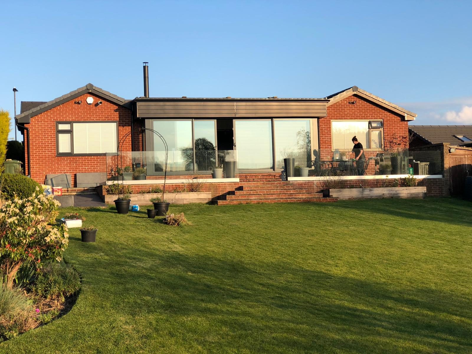 Refurbished brick bungalow with wide glazing and a garden terrace