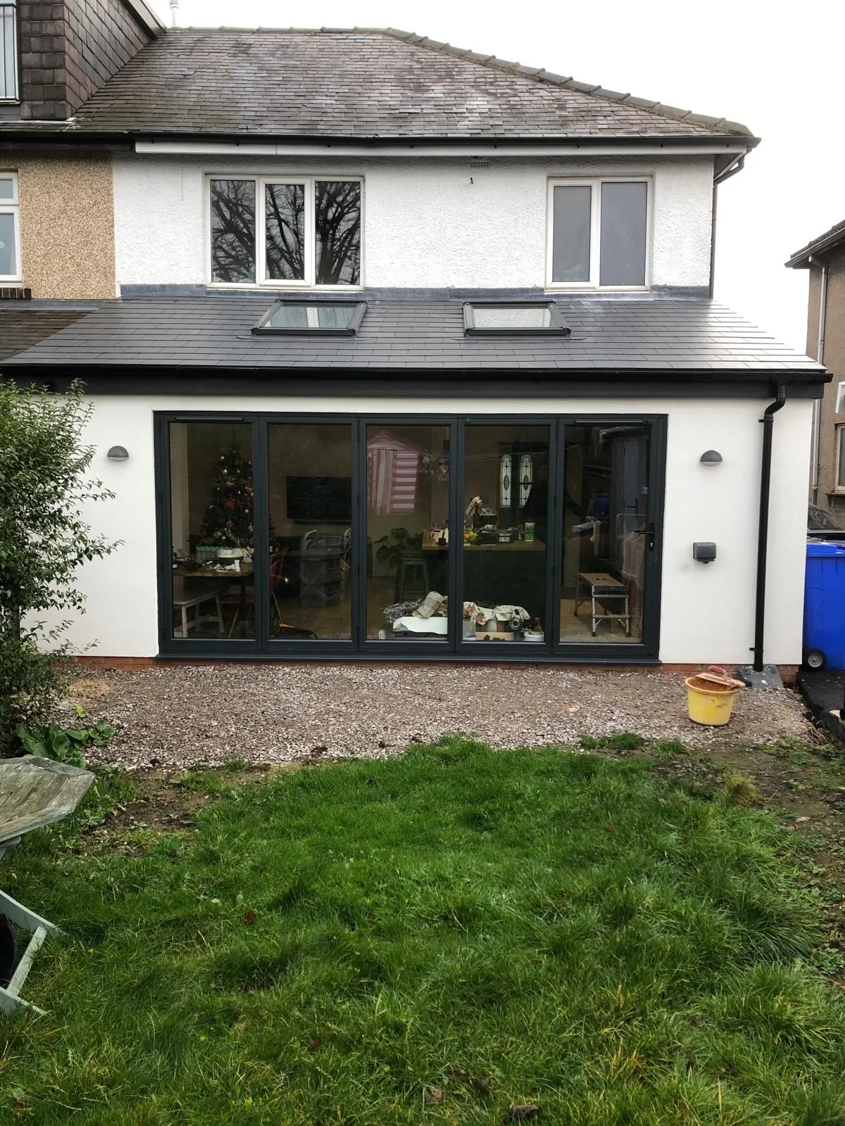 Completed rendered rear extension with rooflights and wide glazed doors