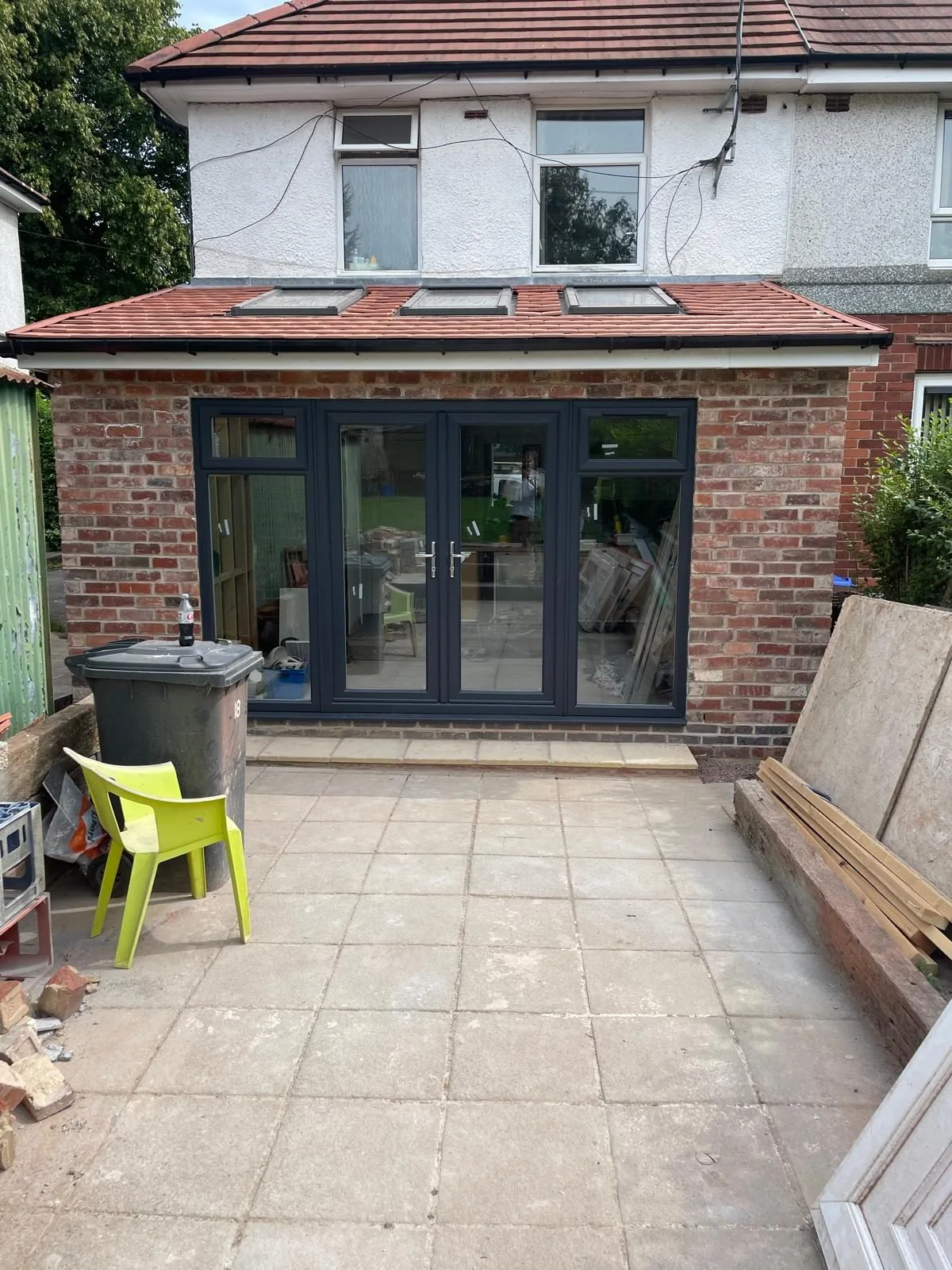 Dark glazed doors in a brick rear extension opening onto paving