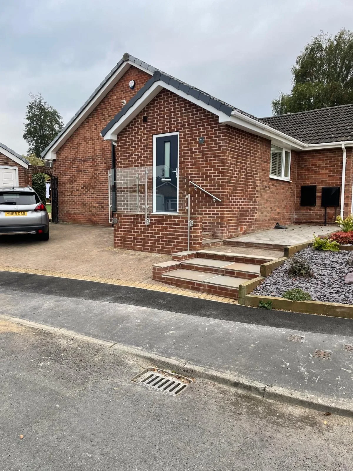 Brick porch and paved entrance viewed from the road