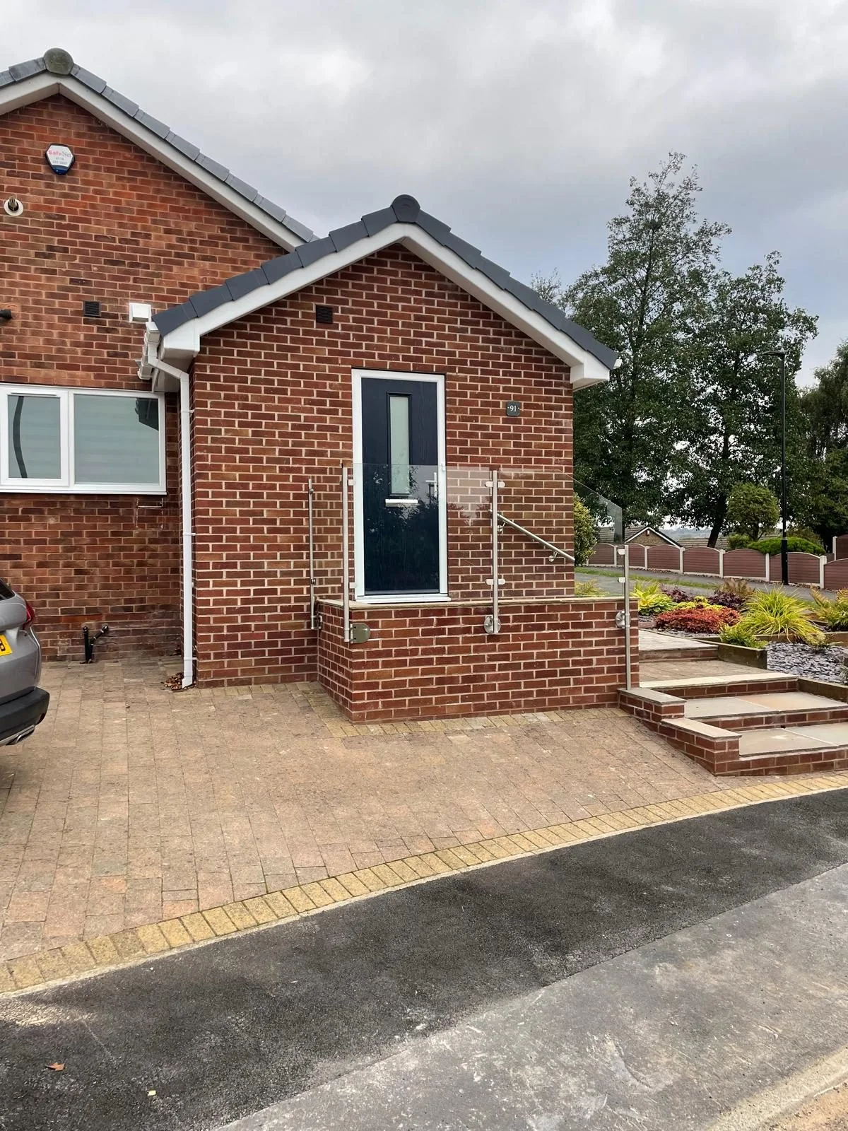 Brick entrance porch with pitched roof and tall glazed door