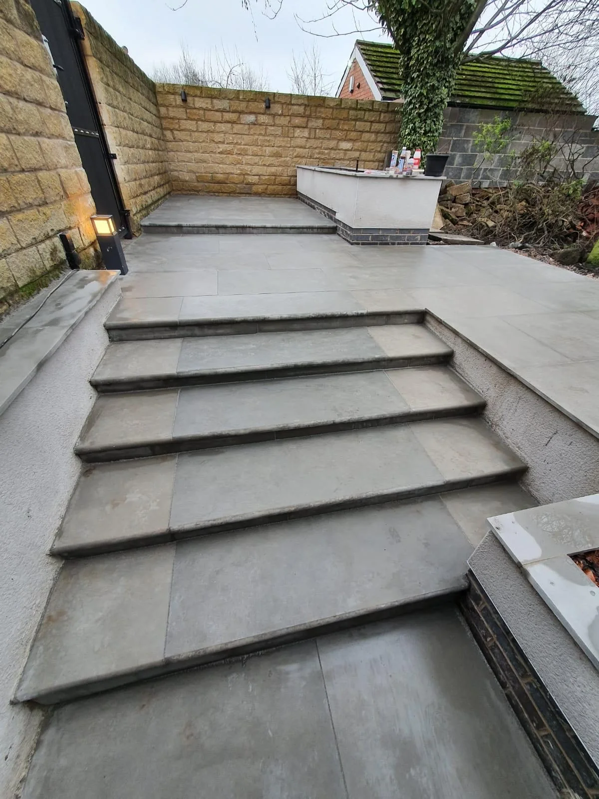 Grey paved garden steps with neat edging and low stone walls