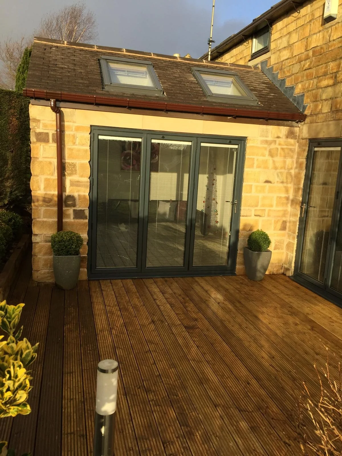 Glazed bifold doors beneath rooflights in a stone rear extension
