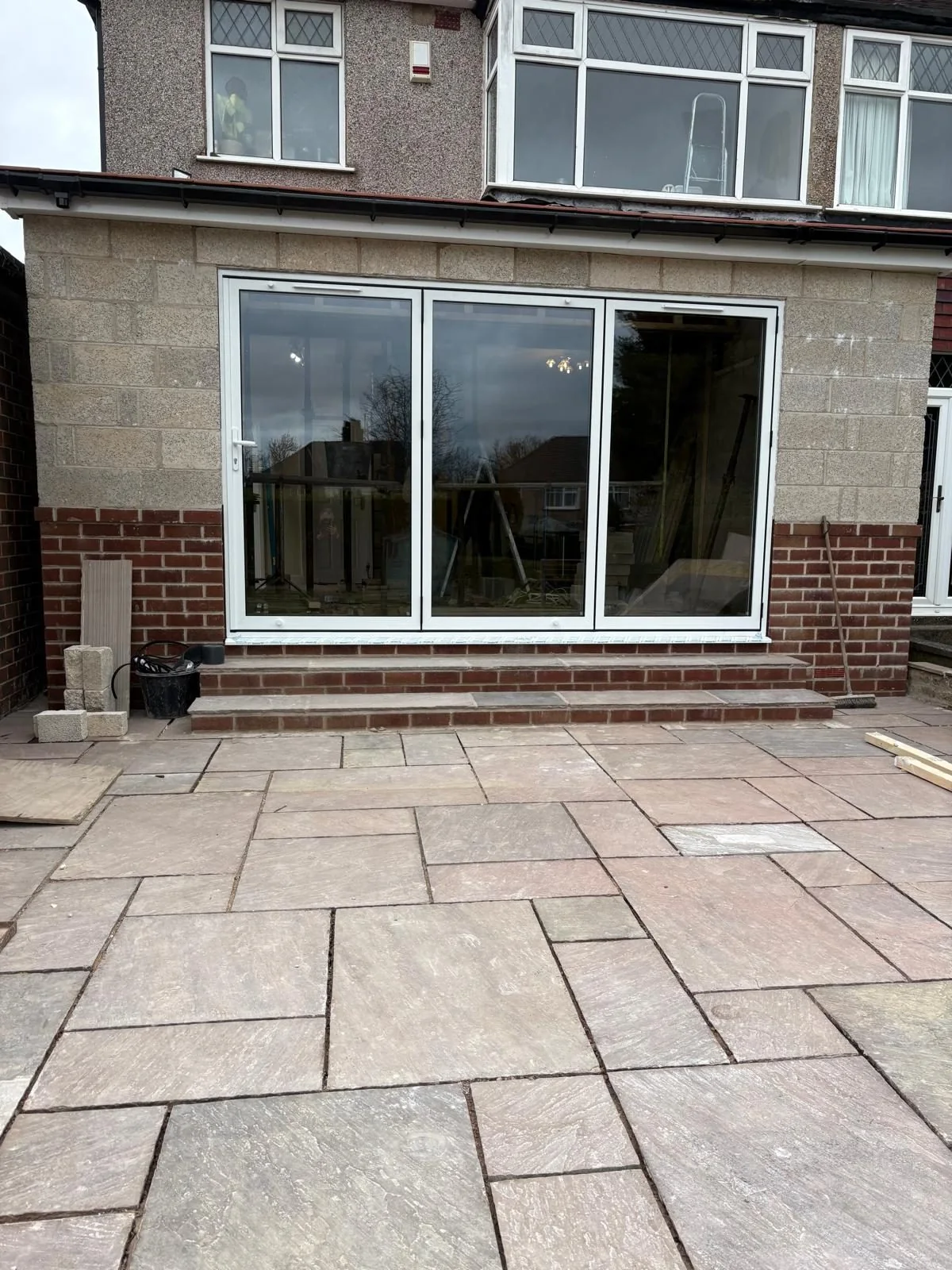 Finished rear extension with wide glazed doors and stone patio