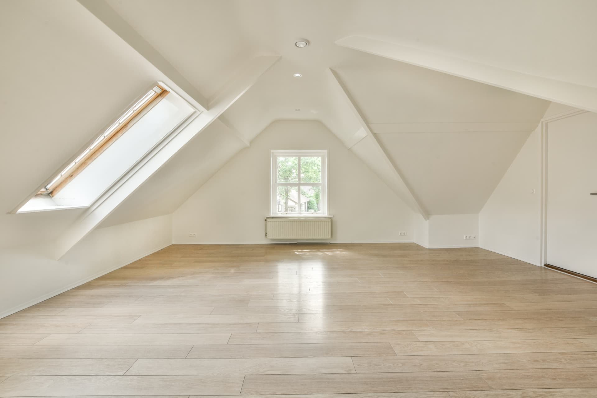Converted loft room with a roof window and timber flooring